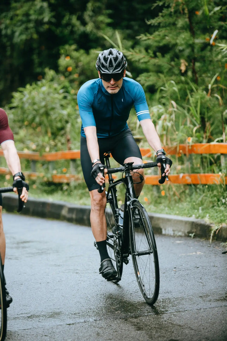 Cyclist in blue jersey riding black road bike in Cycling collection