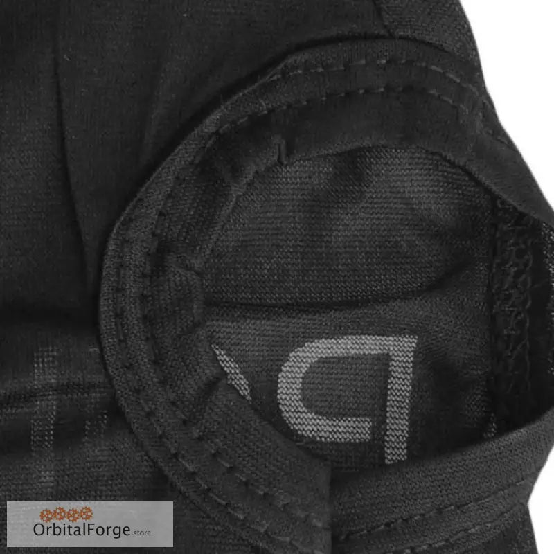 Black fabric patch with stitched edges and a partial logo visible.