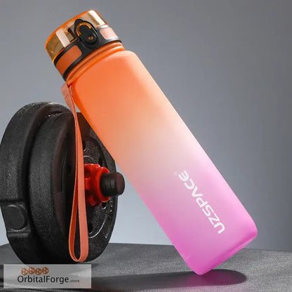 Gradient orange-to-pink reusable water bottle with a flip-top lid and carrying strap.