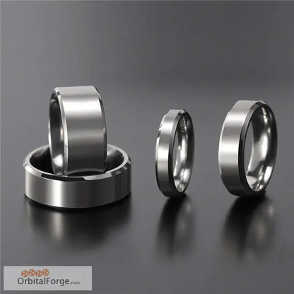 Four brushed silver wedding bands with flat surfaces and beveled edges