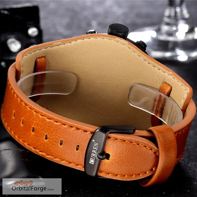 Orange leather watch strap with black buckle and stitched detailing.