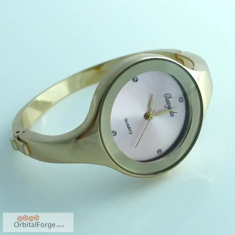 Gold-toned stainless steel women’s cuff watch with a minimalist white dial design