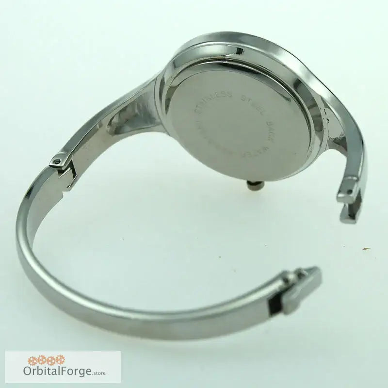 Silver-toned stainless steel cuff watch showcasing elegant design on red face