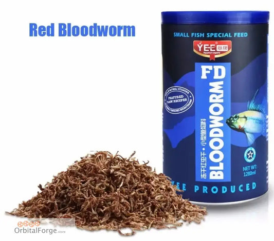 Red bloodworms shown as dried feed next to a blue fish food container.