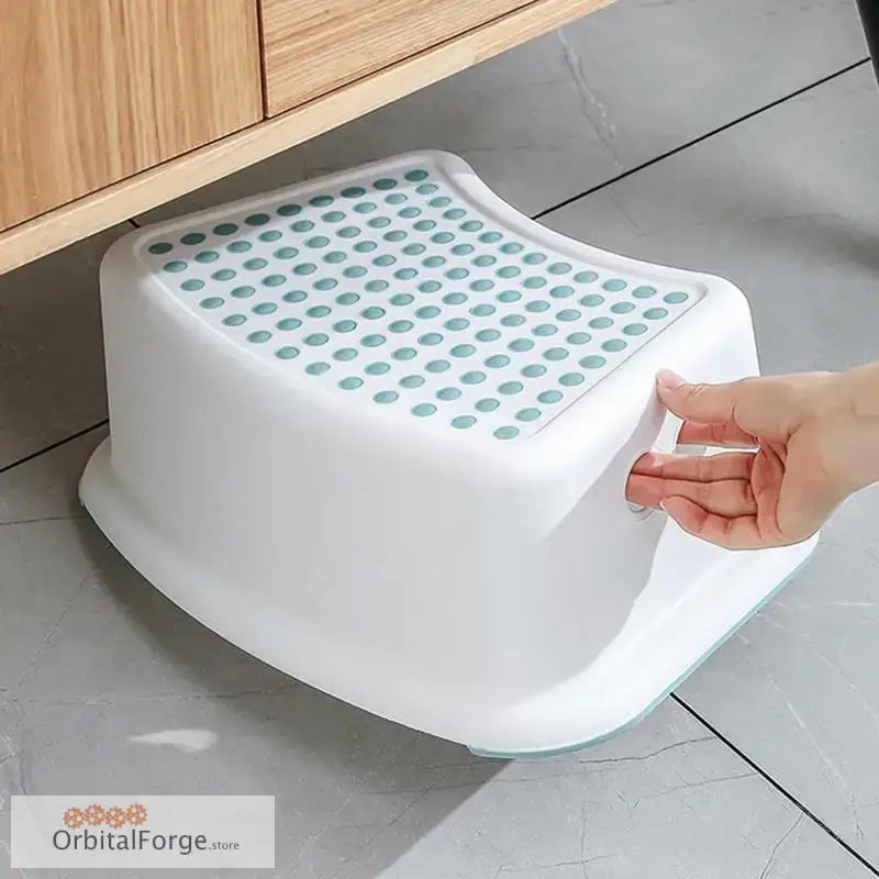 White plastic step stool with mint green non-slip dots on the top surface.