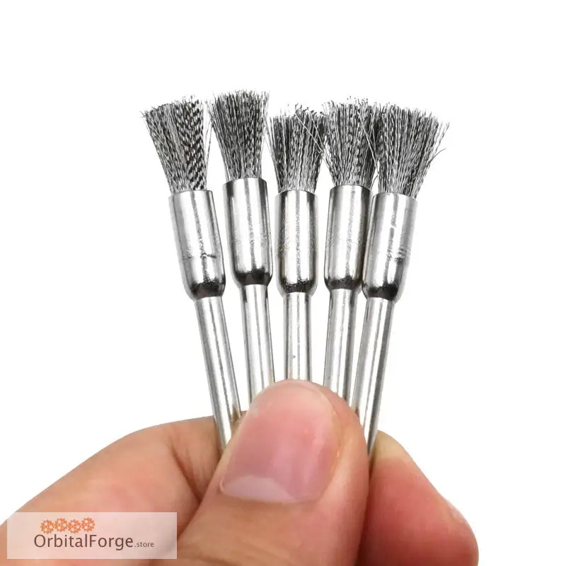 Metal wire cleaning brushes with silver handles held between fingers.